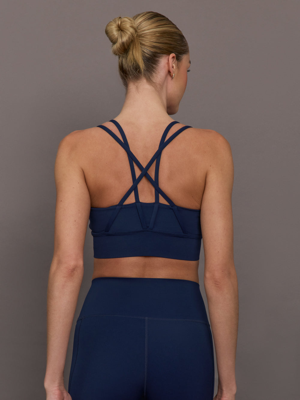 Back view of navy multi strap sports bra showing crisscross strap design.