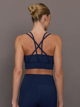 Back view of navy multi strap sports bra showing crisscross strap design.