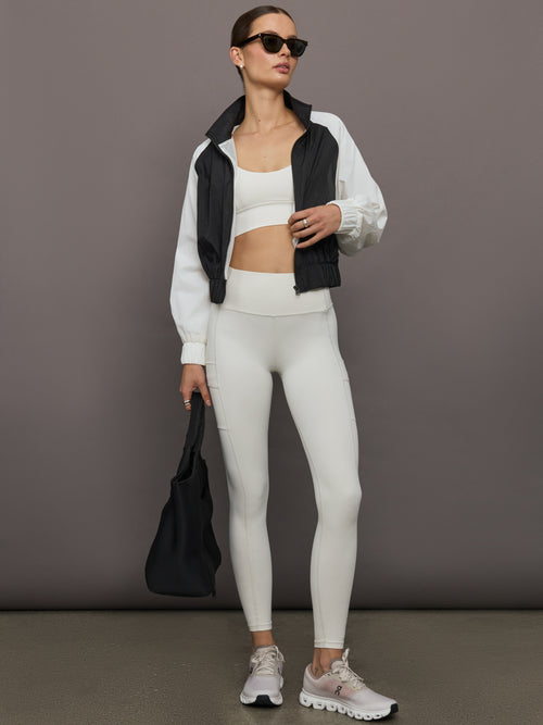 Model wears white active bra with double thin back straps and a smooth, supportive finish.
