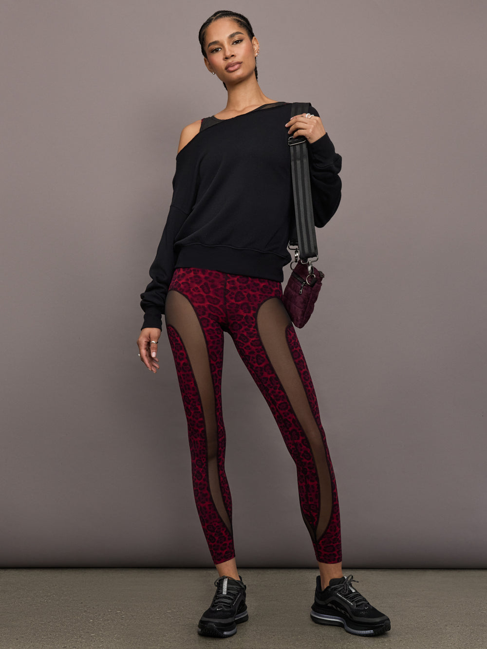 Model is wearing the Red Leopard Melt leggings with a black sweatshirt, full-body view.