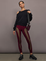 Model is wearing the Red Leopard Melt leggings with a black sweatshirt, full-body view.