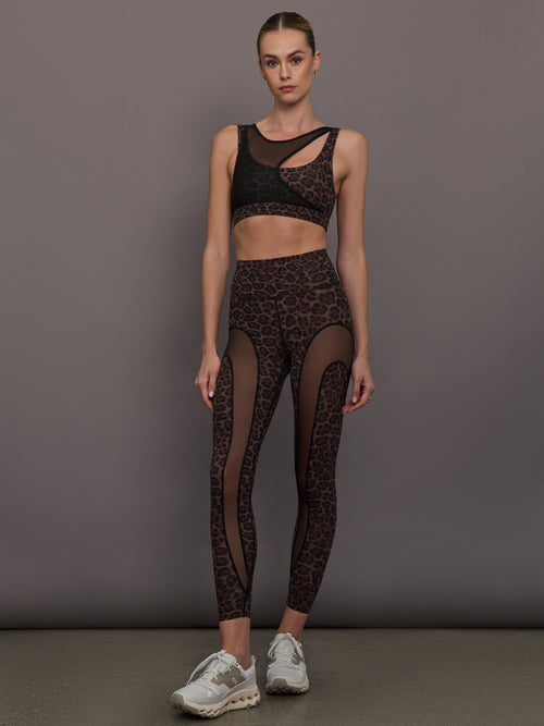 Model wearing a leopard print sports bra with a mesh overlay