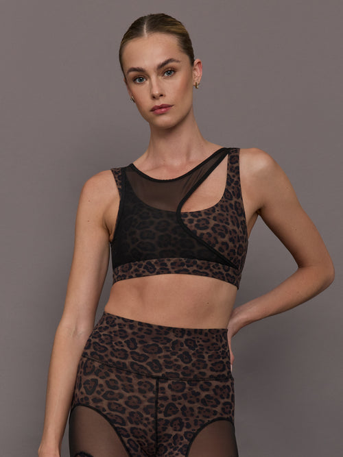 Model wearing a leopard print sports bra with a mesh overlay