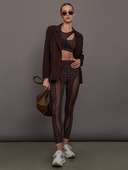 Model wearing a leopard print sports bra with a mesh overlay