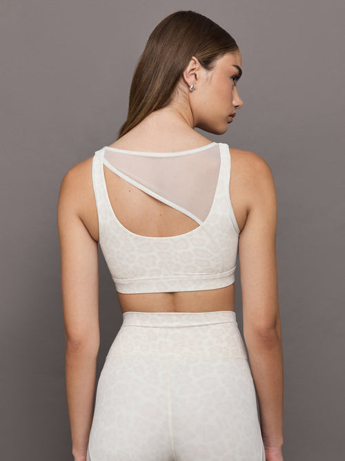 Model wears Snow leopard sports bra with a white mesh overlay, featuring a scoop neckline, wide straps.