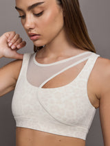 Model wears Snow leopard sports bra with a white mesh overlay, featuring a scoop neckline, wide straps.