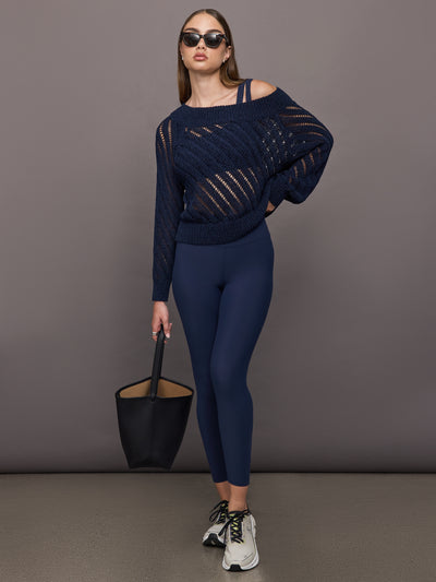 Model wears Black sports bra with double straps on one side and a square neck.