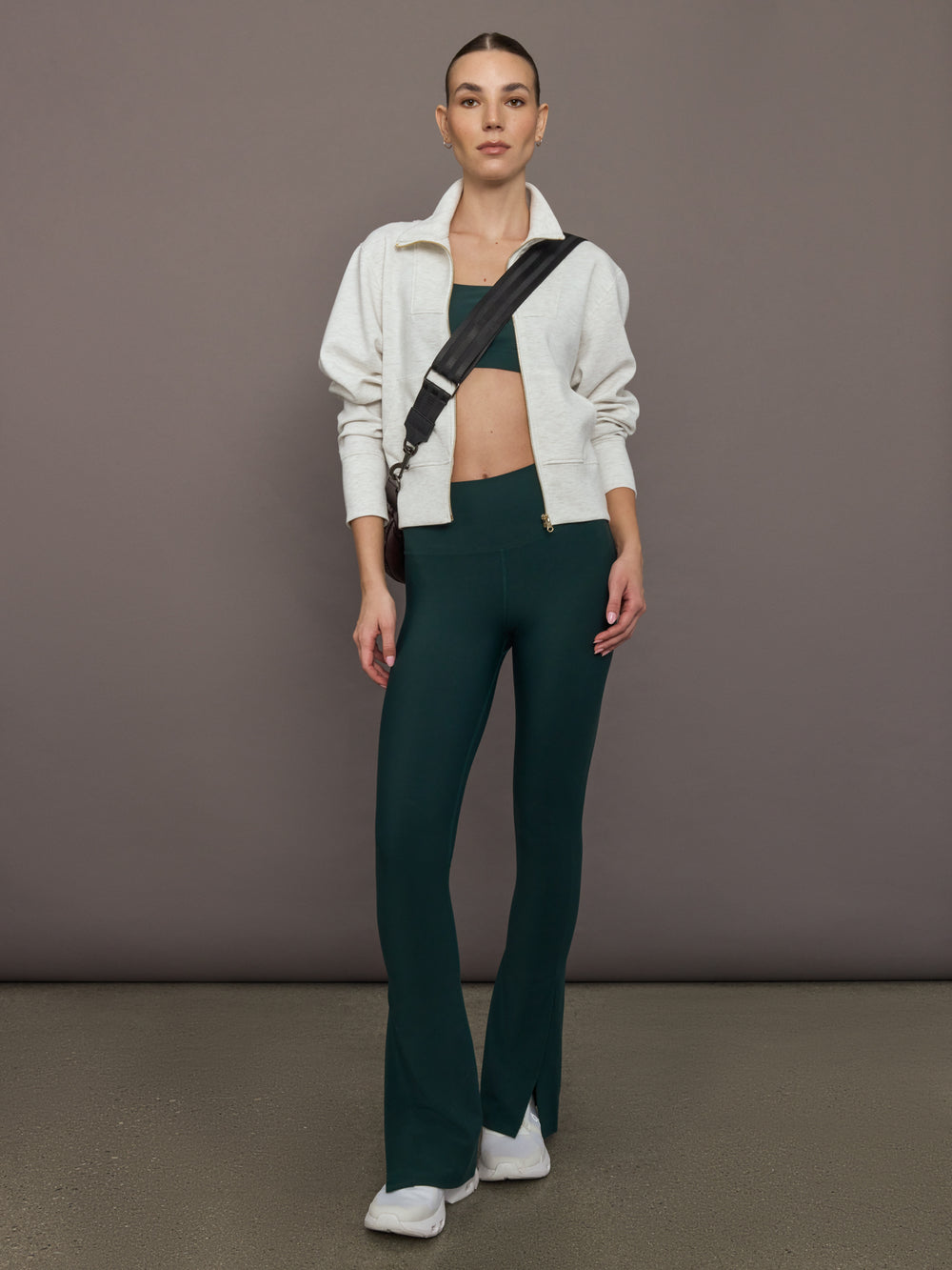Model is wearing the Cutout Bra in Melt Forest, full body view styled with matching pants and zip jacket.