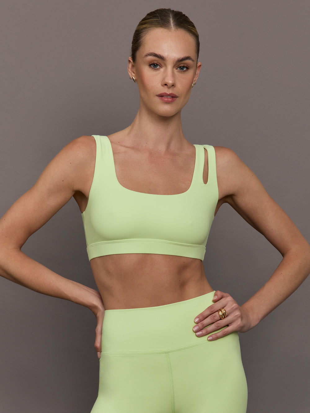 Model wearing a light green cutout sports bra.