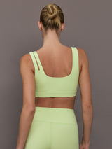 Model wearing a light green cutout sports bra.