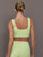 Model wearing a light green cutout sports bra.