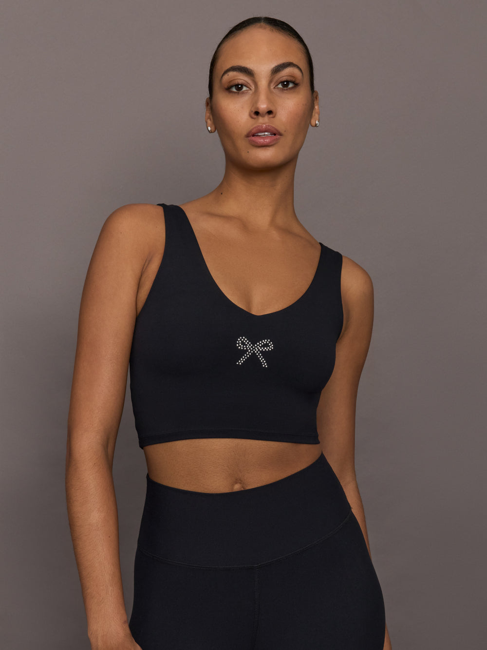 Model wearing Rhinestone Bow Bra in Melt Black with rhinestone bow detail at center front.