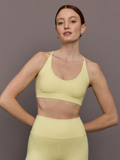 Model is wearing Melt Rib V-Neck Bralette in Banana, front view.