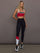 Model is wearing Melt Double Layered Sports Bra in Black, Crimson, and White Binding, full body front view styled with leggings.