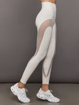 Model wears snow leopard leggings with sheer mesh spliced panels along the legs, a high-rise waistband, and a sleek, form-fitting silhouette.