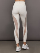 Model wears snow leopard leggings with sheer mesh spliced panels along the legs, a high-rise waistband, and a sleek, form-fitting silhouette.