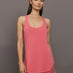 Model wears long racerback rosewood colored tank top with a loose fit and scoop neckline.