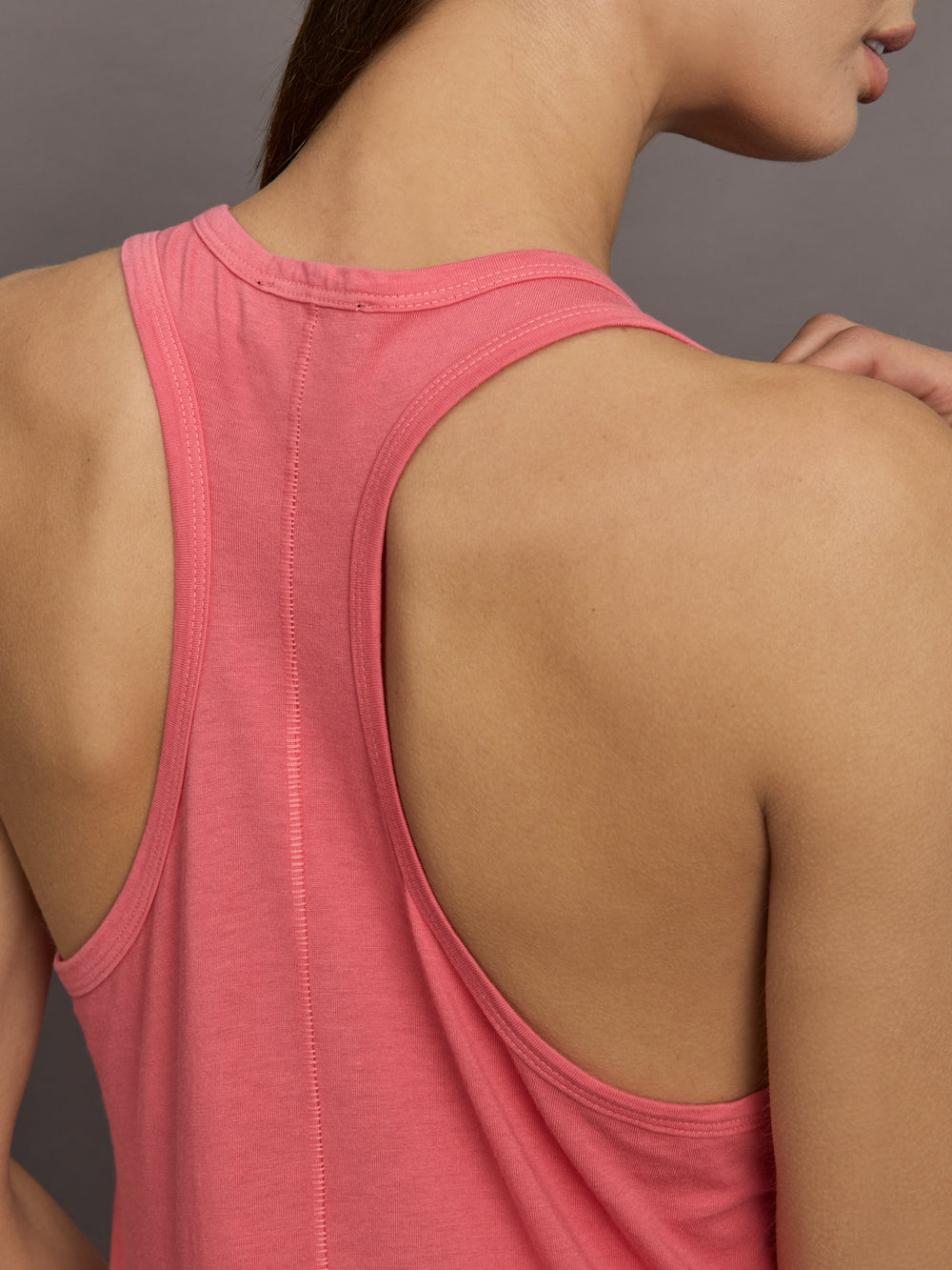 Model wears long racerback rosewood colored tank top with a loose fit and scoop neckline.
