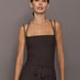 Model is wearing a dark brown square-neck tank top with thin double straps, front view.