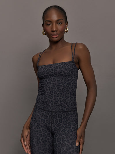 Model wears a tank top with double spaghetti straps in a dark gray leopard print. 