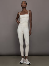 Model wears a buttery soft athleisure double strapped tank with cross back in a snow leopard print. 