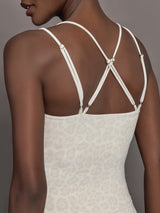 Model wears a buttery soft athleisure double strapped tank with cross back in a snow leopard print. 