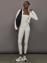 Model wears a buttery soft athleisure double strapped tank with cross back in a snow leopard print. 