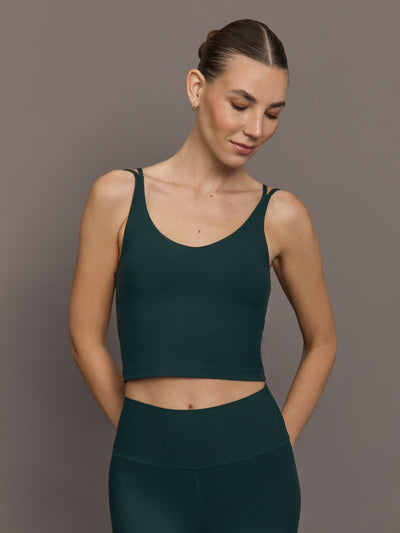 Model is wearing the V Neck Tank in Forest, front view.