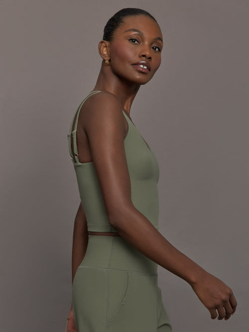 Model wears an army green tank top with double straps. 