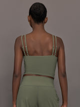 Model wears an army green tank top with double straps. 