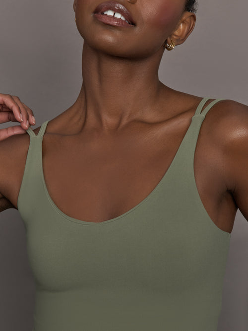 Model wears an army green tank top with double straps. 