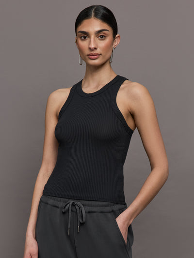 Model wears a black high neck ribbed jersey tank. 