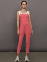 Model wears a rosewood colored tank top with thick white straps and a scoop tank neckline.