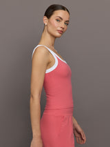 Model wears a rosewood colored tank top with thick white straps and a scoop tank neckline.