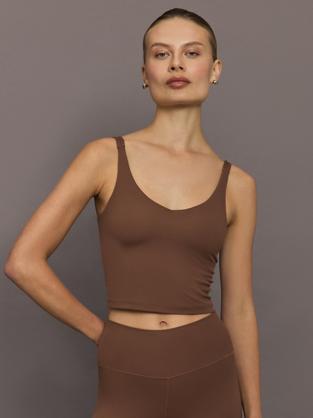 Front view of women’s ribbed melt v-neck tank in cocoa brown, cropped activewear top styled with matching leggings.