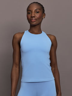 Model is wearing Racer High Neck Active Tank in Serenity, front view.