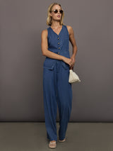 Model wears medium wash vest with a button-down front and sleeveless design.