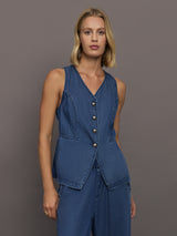 Model wears medium wash vest with a button-down front and sleeveless design.