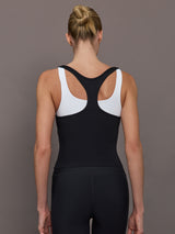 Model wearing a black and white colorblock tank top.
