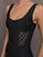 Model wears a black tank top with laser cutout paneling along riblines bilaterally. 