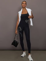 Rhinestone Bow Tank in Melt Black styled with matching leggings, white sweater draped, and black handbag.
