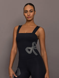 Model wearing Rhinestone Bow Tank in Melt Black, front view with rhinestone bow detail at side.