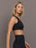Model is wearing Melt One-Shoulder Cropped Tank in Black, side profile view.