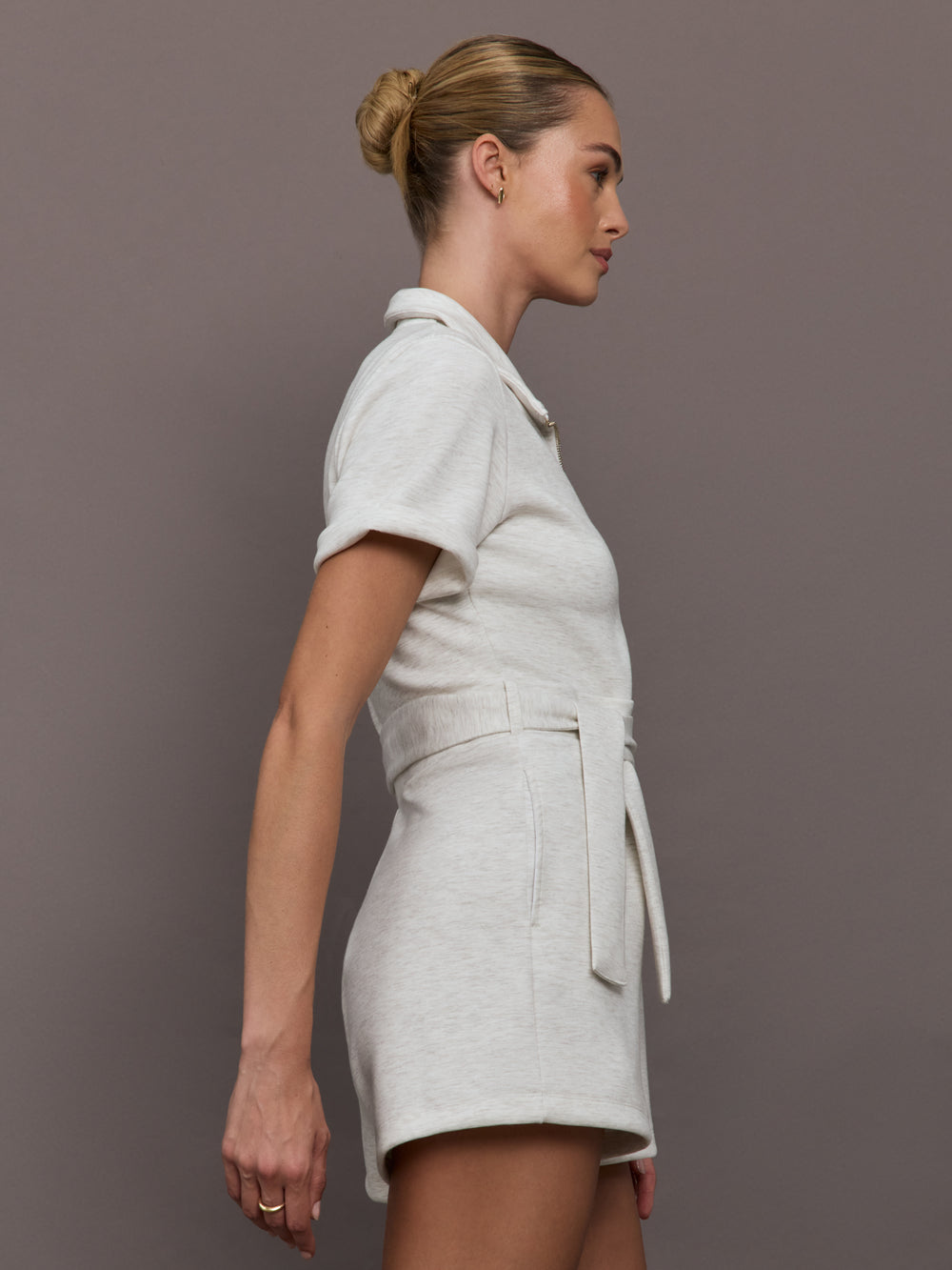 Model wearing a light gray romper with zipper closure.