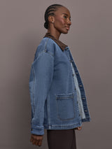 Model is wearing the Denim Barn Jacket in Dark Wash, side profile view