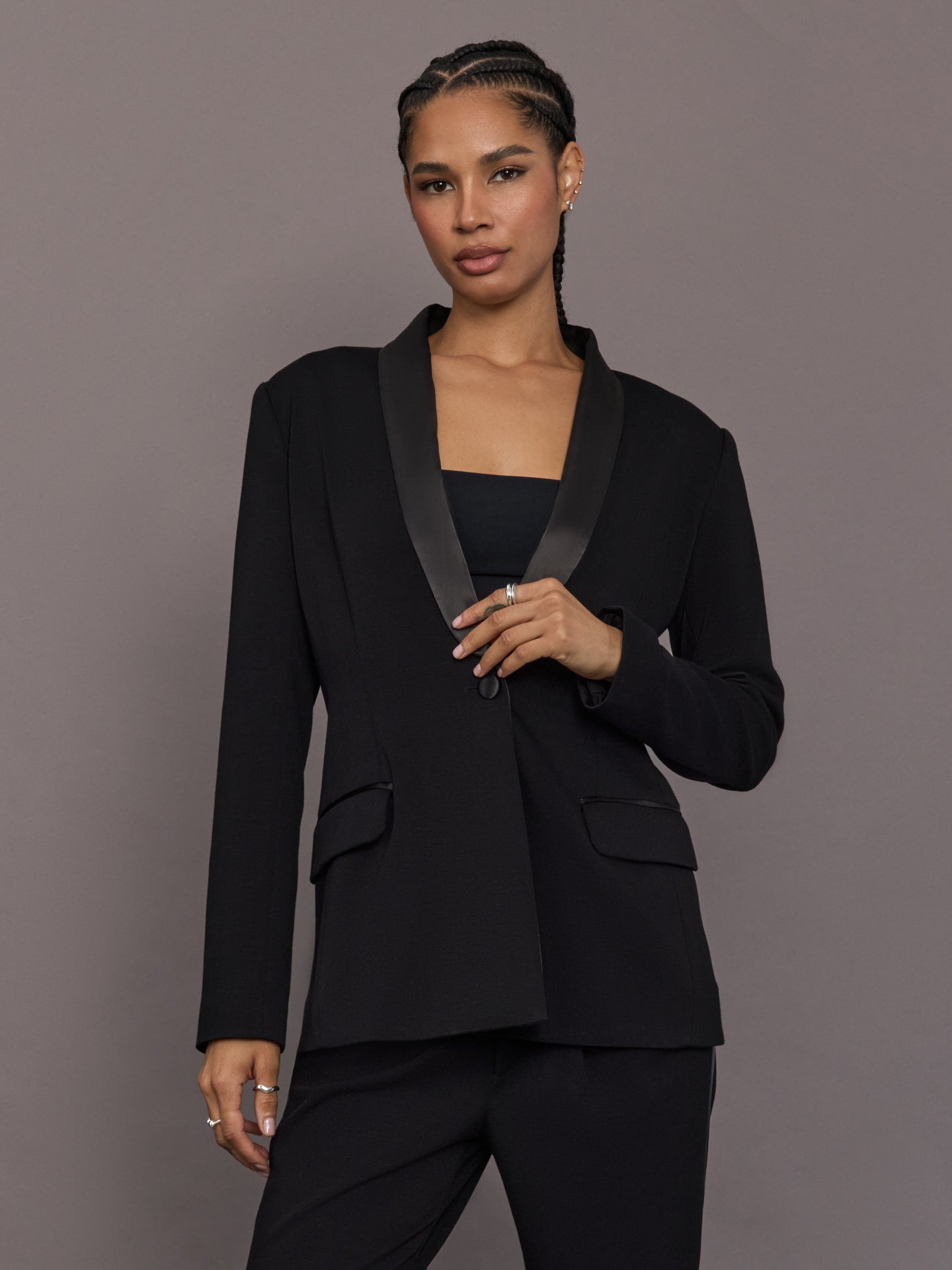 Model is wearing the Tuxedo Blazer in black, front view with satin lapel detail.
