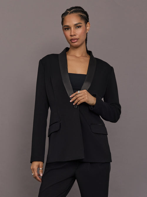 Model is wearing the Tuxedo Blazer in black, front view with satin lapel detail.