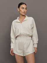 Model wears lightweight windbreaker with a snow leopard print, front zipper, and collared neck.




