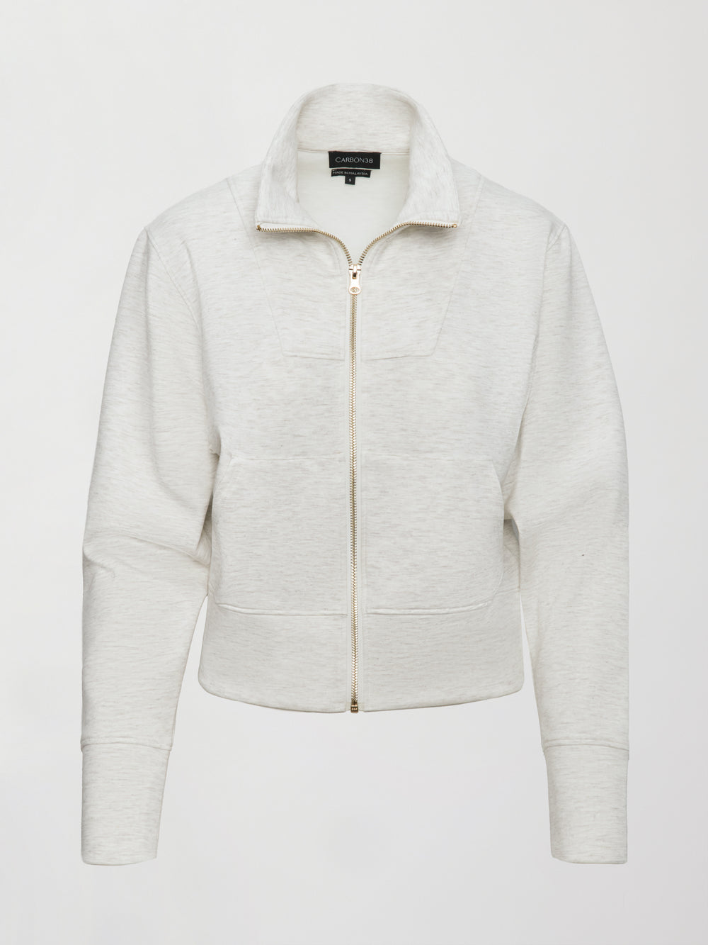 Model wears ivory Interlock Full Zip Jacket featuring a sleek, minimalist design with a high collar and full-length zipper.