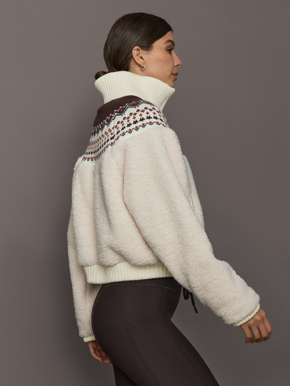 Fairisle Sherpa Jacket in nude sherpa with ribbed cuffs and Fairisle knit detail, side view.